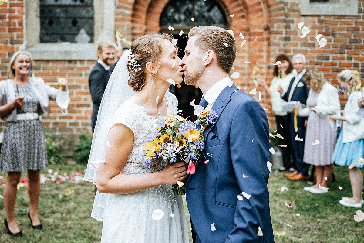 kuss vor kirche, brautpaar, hochzeit auf dem flosshof, hochzeitsfotograf altmark